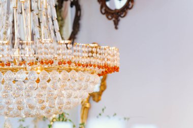 Tavandan sarkan çarpıcı bir kristal avize yumuşak ışık ve zarafet sağlıyor..