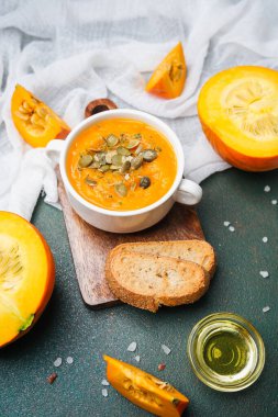 Kasede portakal çorbası, balkabağı dilimleri ve masada ekmek.