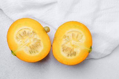 Turuncu kabak, beyaz bez arkaplanlı tohumları ve posaları göstererek ikiye bölündü