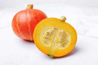 Beyaz arka planda tohumlu turuncu balkabağı.