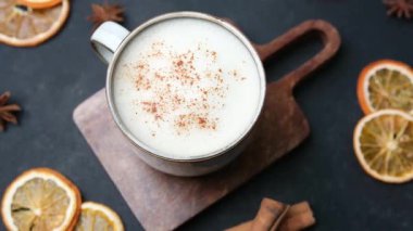Tarçınlı kremalı içecek ve koyu arkaplanda kurumuş portakallı yıldız anason.