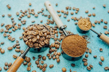 Kahve, hazır kahve ve mavi arka planda kepçelerle fasulye.