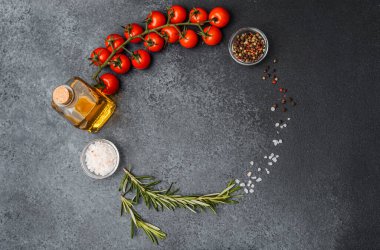 Mutfak malzemeleri domates yağı, tuz biberiyesi ve koyu arkaplanda biber.