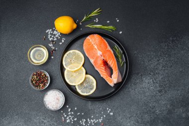 Limon dilimleri ve otlarla süslenmiş somon filetosu pişirmek için hazırlandı..