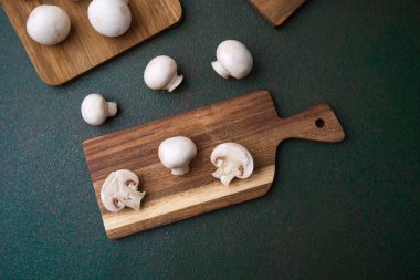 Güvertede beyaz şampanyalı mantarlar var. Görsel bileşim veya yemek dokusu için dağınık bir düzen var. 