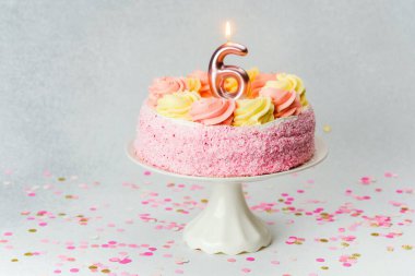 Dondurmayla süslenmiş pembe bir doğum günü pastası ve kutlamayı bekleyen altı numaralı mum..