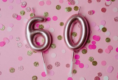 Altmış numarayı temsil eden mumlar pembe arkaplanda canlı konfetilerle sergilenir.