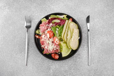 Yemek planı veya vejetaryen yemek balosu için çatal bıçaklı armut peynirli salata üst görünümü