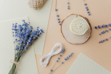 Mumlar malzemeler ve bej yüzeyde lavanta çiçekleri yapıyordu.