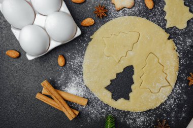 Noel kurabiyesi hamuru ve merdaneli fırın sahnesi mevsimlik hazırlık konsepti için yumurta ve baharatlar.