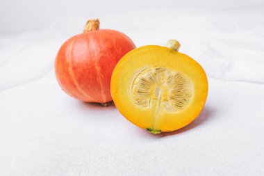 İki balkabağı, bir bütün ve bir yarım, tohumlar görünür bir ışık yüzeyinde