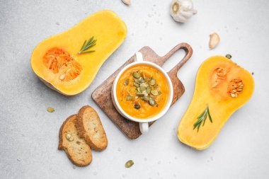 Kavanozda tereyağlı kabak çorbası kızarmış ekmek ve kabak çekirdekleri ile ahşap bir tahta üzerinde..