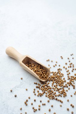 Beyaz sırtüstü kişniş tohumlu ahşap kepçe.