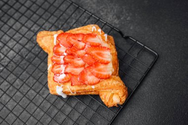 Lezzetli çilekli pasta, sıcak bir mutfak ortamında soğutma rafında durur..