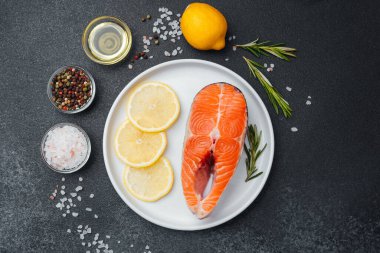 Limon dilimleri, otlar ve baharatlı somon filetosu pişirmeye hazır..