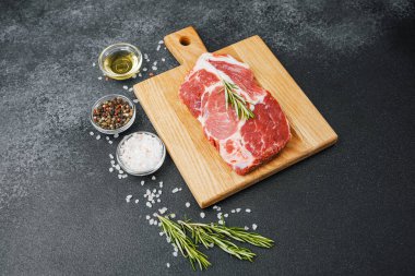Biberiyeli çiğ biftek ve ahşap tahtada baharatlar.