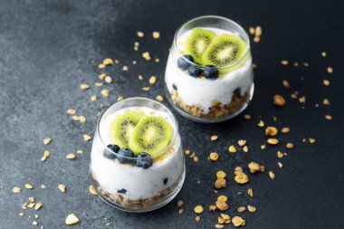 Koyu arkaplanda kivi ve yaban mersinli sağlıklı kahvaltı.