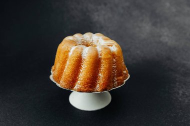 Koyu taşlı, beyaz tezgahta altın demet kek.