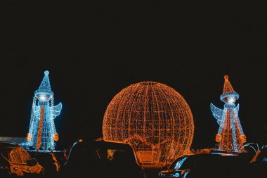 Parlak melek figürleri ve gece vakti arabalarla aydınlık küre dekoru.