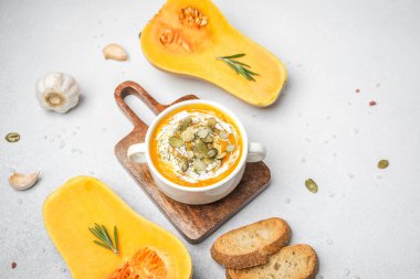 Krema ve kabak çekirdekli kabak çorbası, ekmek ve biberiye ile servis edilir.