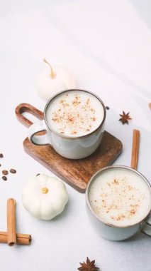 Tarçınlı sıcak kremalı içecekler ve küçük balkabaklarıyla süslenmiş yıldız anason.