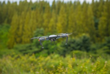 The cropped shot view of a black drone flying in the nature.