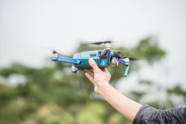 Cropped shot view of human holding a flying drone in his hand.