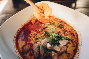 Tom Yum Goong (or Spicy prawn soup) mixed with meat ball noodles, Thai style and iconic popular taste of Thai foods.