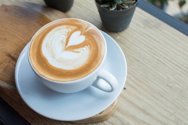 Dondurucu gün için yüzeyinde latte resmi olan kahve fincanı..