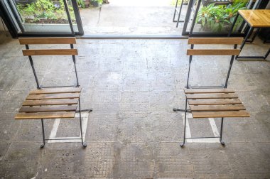 Üzerinde kimse oturmadan boş bir sandalye, iki sandalye arasına mesafe koymak Covid-19 'un yayılmasını önlemek için sosyal mesafeyi ayır. Sosyal uzaklık kavramı.