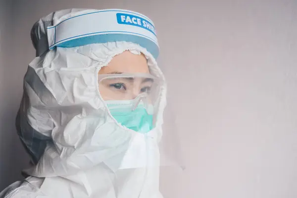 Healthcare worker while wearing PPE suit before working in hospital during Covid-19 pandemic. PPE is equipment that will protect the user against health or safety at work.