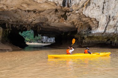 Vietnam 'daki UNESCO dünya mirası sahasında Halong Körfezi' ndeki kanoyla turist ziyareti. Bu kavisli mağaranın kendine özgü bir cazibesi var. Çünkü gerçekten doğal bir yer..