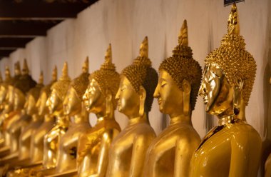 Phitsanulok vilayetindeki Wat Phra Sri Rattana Mahathat tapınağında oturan Buda heykeli grubu..