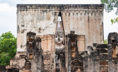 Wat Si Chum Tapınağı 'nın çatısındaki devasa Buda heykeli Sukhothai Tarihi Parkının kuzey bölgesinde, duvarlarla çevrili şehrin dışında yer almaktadır..