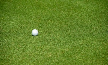 Golf sahasında bir golf topu. Yeşil, golf sahasında her deliği çevreleyen özel bir çimen alanıdır..