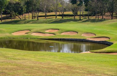 Golf sahasındaki kum sığınağı manzarası. İniş bölgesinde veya yeşil alanda istenen pozisyonu korumak için golf deliğine bir sığınak yerleştirildi..