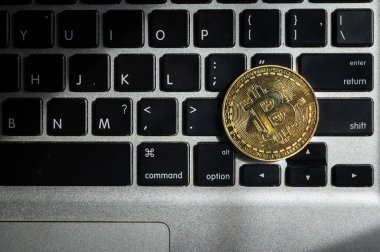 Bilgisayar klavyesinde altın bir Bitcoin jetonu. Kripto para, mal ve hizmetleri satın almak için kullanılabilecek jeton ya da bozuk para şeklini alan sanal ya da dijital bir paradır..