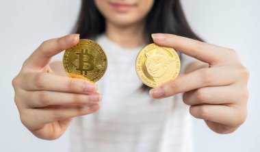 Bitcoin ve Dogecoin jetonları tutan kadın. Kripto para, mal ve hizmetleri satın almak için kullanılabilecek jeton ya da bozuk para şeklini alan sanal ya da dijital bir paradır..