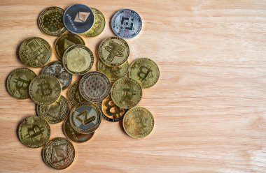 Tahta masadaki çeşitli kripto para jetonlarının üst görüntüsü. Kripto para birimi, kriptografi ile korunan dijital veya sanal para birimidir..