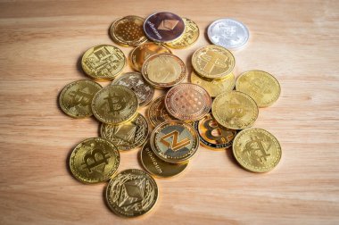 Tahta masadaki çeşitli kripto para jetonlarının üst görüntüsü. Kripto para birimi, kriptografi ile korunan dijital veya sanal para birimidir..