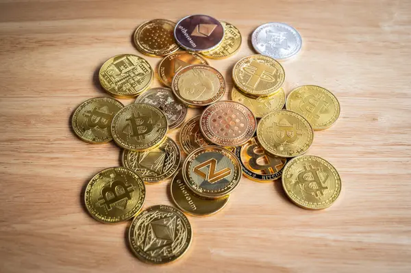 Tahta masadaki çeşitli kripto para jetonlarının üst görüntüsü. Kripto para birimi, kriptografi ile korunan dijital veya sanal para birimidir..