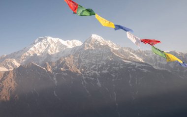 Nepal 'in Annapurna bölgesindeki Annapurna Dağı (7,219 m) ve Hiunchuli Dağı' nın (6,441 m) güneşten önce rüzgarda dalgalanan bayraklar Nepal 'in Annapurna bölgesinde Mardi Himal bakış açısından görülüyor.. 