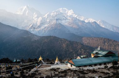 Arka planda Kangtega Dağı (6,779 m) ve Thamserku Dağı (6,608 m) ile Nepal 'in Pangboche köyünde Tibet stupası.