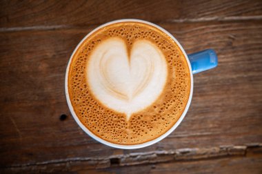 Tahta masada servis edilen sıcak bir Cappuccino kahvesi.. 