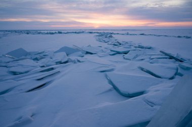 Güneşin doğuşunda Baykal Gölü 'nün üzerinde buzdan bir hummeğin yükseldiği Uzury Körfezi manzarası. Uzury, Olkhon adasının doğu yakasında bulunan çok küçük bir yerleşim birimidir..