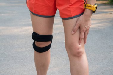 Dizinde ağrı olduğunda destek için dizlik takan kadının keskin nişancı görüntüsü..