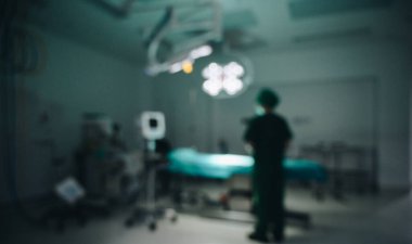 Hastanedeki ameliyathanede (ya da cerrahi odasında) duran sağlık çalışanının bulanık görüntüsü. Arkaplan olarak bulanık işletim odası kullanımının bir resmi.
