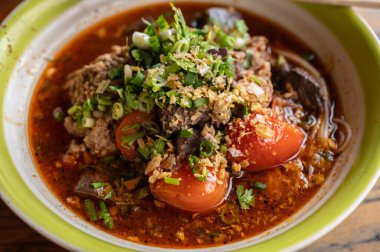 Khanom Jeen Nam Ngeow 'un (Kuzey Tayland Baharatlı Erişte Çorbası) kapanışı masada servis edilir. Baharatlı Erişte Çorbası Tayland-Yai 'den etkilendi. Bu yemek artık ikonik bir Kuzey Tayland yemeği oldu..