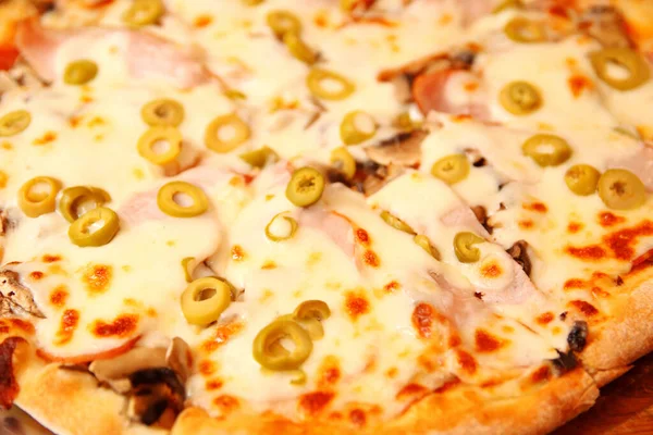 İtalyan pizzasının arka planındaki yeşil zeytinli defocus. Rendelenmiş Mozzarella 'lı Tortilla. Zeytinli pizza, fesleğen ve peynir yakın plan. Pizzacı dışarıda. Odaklanamıyorum.