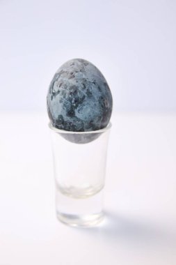 Defocus one blue egg. Close up Easter egg pastel colored on white background. Minimal Easter celebration concept. Design, visual art, minimalism. Balance harmony concept. Mental health.Out of focus.